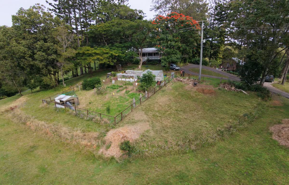 Aerial view of the property before the work: mown grass across the paddock beside the fenced garden